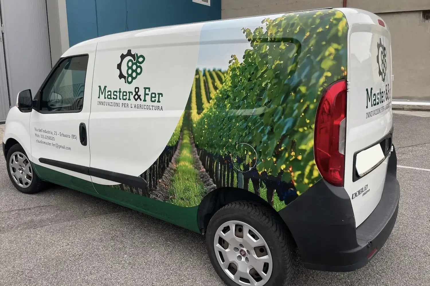 Fiat Doblo aziendale con grafica laterale raffigurante un vigneto e il logo di Master&Fer, azienda di innovazioni per l'agricoltura con sede a Erbusco, Brescia.